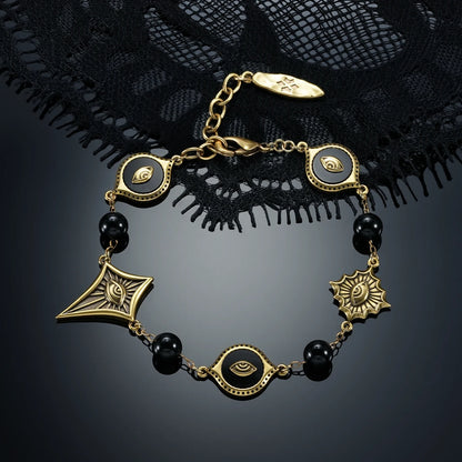 Gold-tone Unseen Orbit Bracelet displayed in a circular arrangement against black lace on a dark reflective surface.