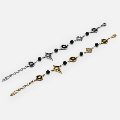 Antiqued silver- and gold-tone Unseen Orbit Bracelets displayed fully extended to show the eye-shaped links, black beads, and clasps.