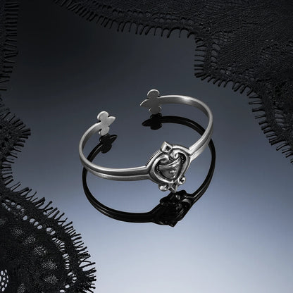 Antiqued silver-tone Veiled Seer Cuff Bracelet displayed on a dark reflective surface against black lace.