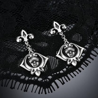 Antiqued silver-tone Veiled Seer Drop Earrings displayed as a pair against black lace on a dark reflective surface.