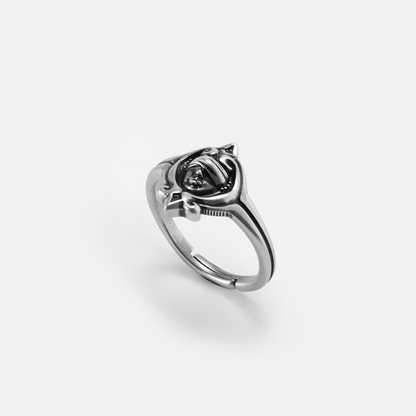 Antiqued 925 sterling silver Veiled Seer Ring shown from an angled view with a blindfolded face motif, pointed eye-shaped frame, and open band.