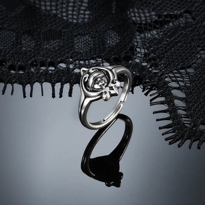 Antiqued silver Veiled Seer Ring displayed from the side on a dark reflective surface, showing the open band and raised centerpiece.