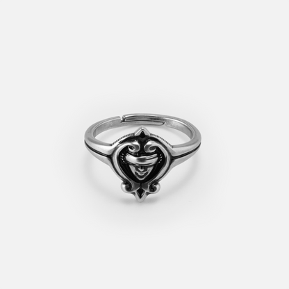 Front view of the antiqued silver Veiled Seer Ring with a blindfolded face set inside a pointed eye-shaped frame.