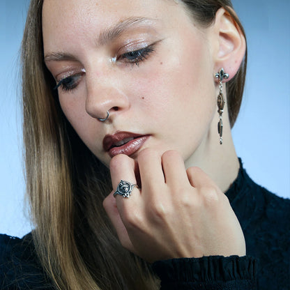 Front portrait showing an antiqued silver Veiled Seer Ring worn near the face with its blindfolded seer motif clearly visible.