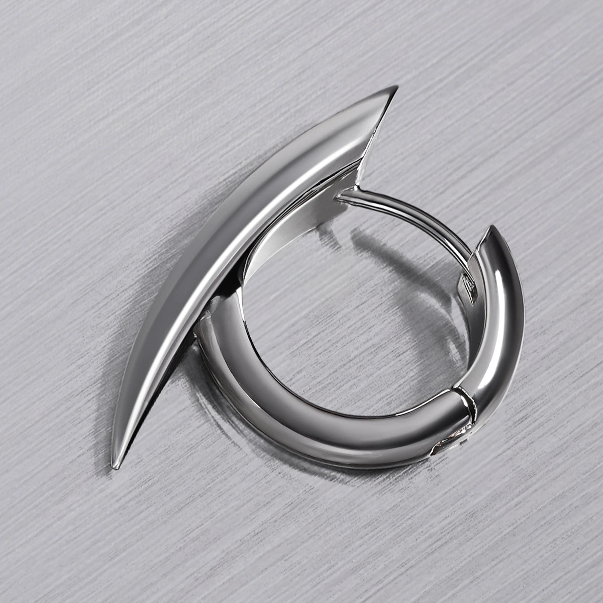 Close-up of silver Venom Claw hoop earring with curved fang-shaped outer edge
