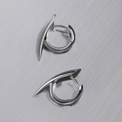 Pair of silver-tone claw hoop earrings laid flat on a brushed metal surface