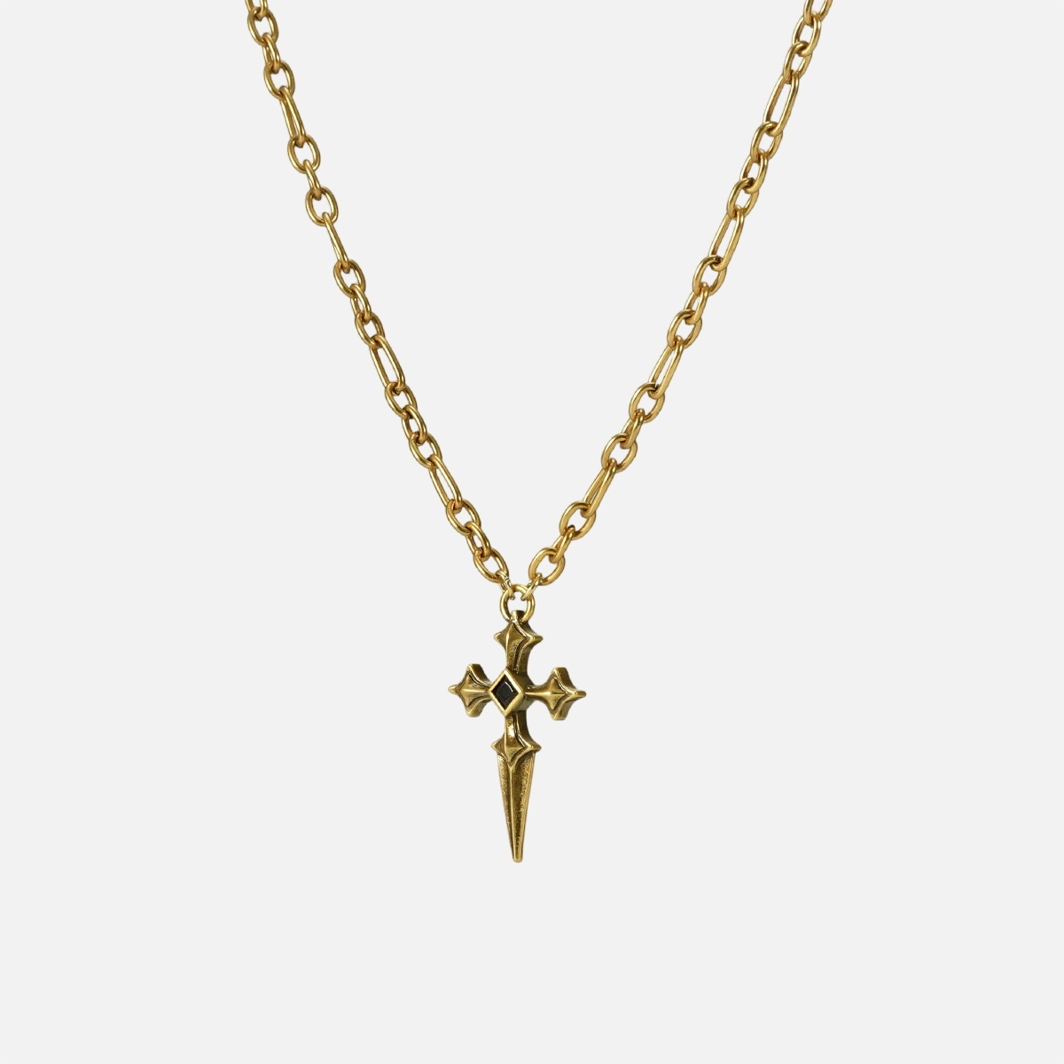 Vesper Blade Necklace in gold shown vertically on white, highlighting the blade-shaped cross pendant and chain detail.