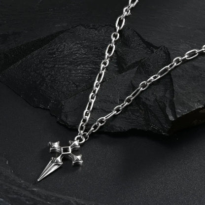 Silver Vesper Blade Necklace laid across black textured fabric with the blade-shaped cross pendant in view.