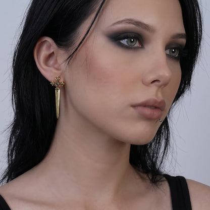 Vesper Blade Stud Earrings in antiqued 18K gold worn on the ear in a front three-quarter portrait with dark hair.