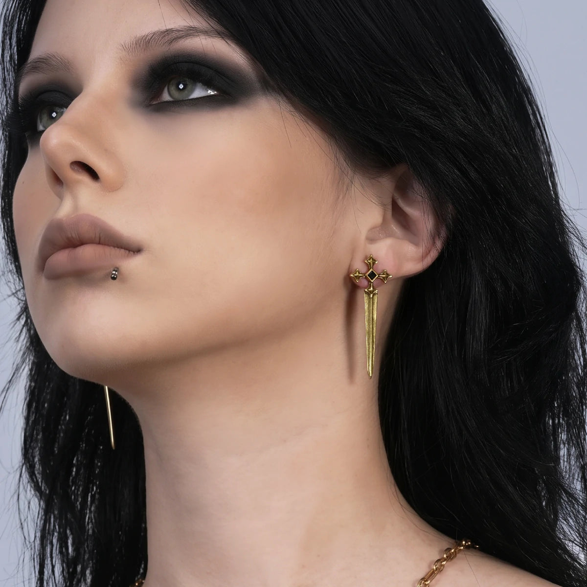 Vesper Blade Stud Earrings in antiqued 18K gold worn on the ear in an upward-looking side-profile portrait.