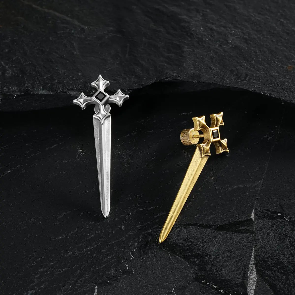 Silver and gold Vesper Blade Stud Earrings arranged as contrasting single pieces on black textured fabric.