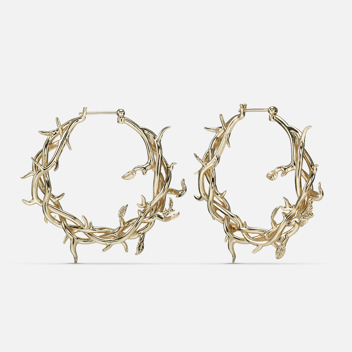 Gold-tone Vine Whispers hoop earrings shaped from twisting thorny branches