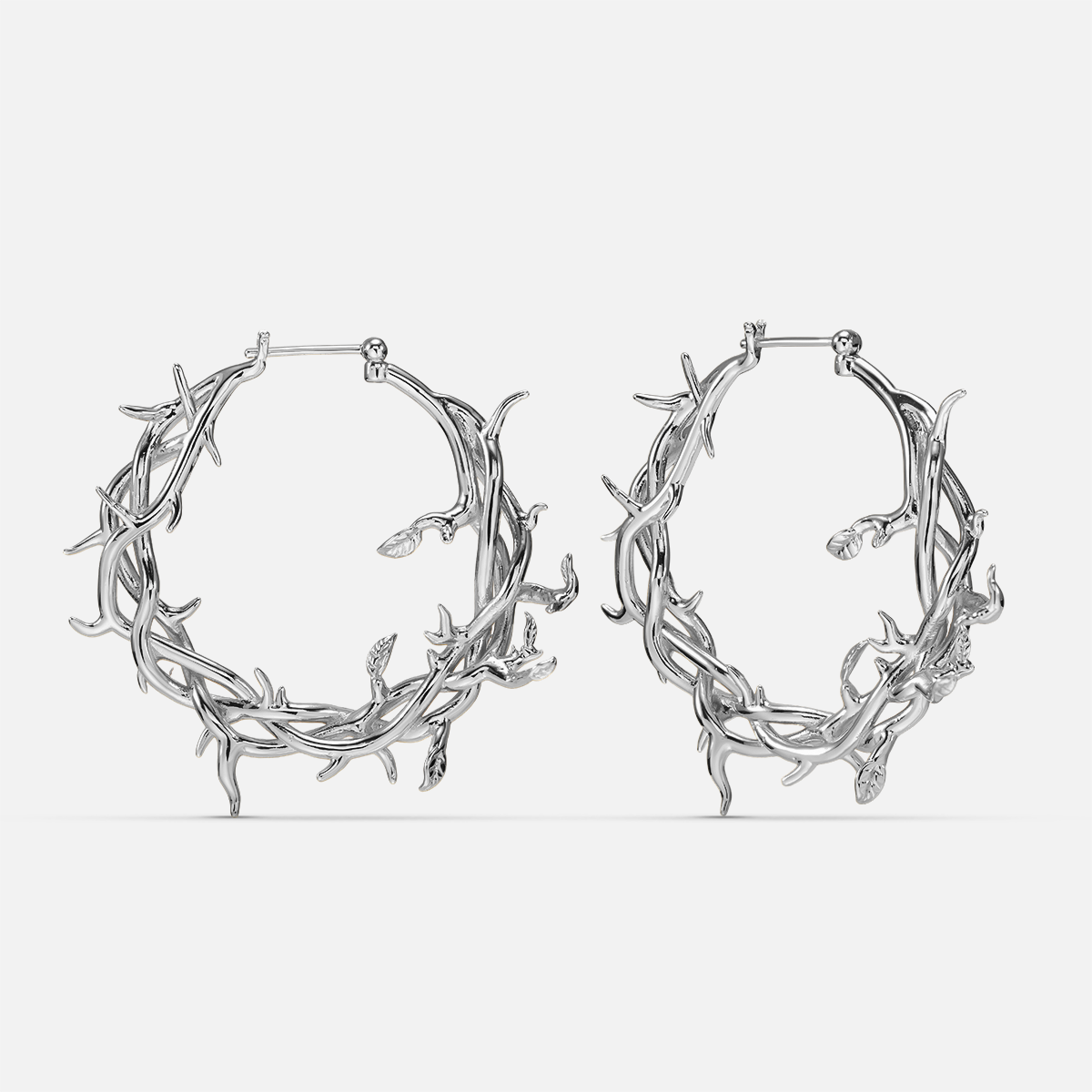 Pair of silver-tone hoop earrings featuring an intertwined vine and thorn design