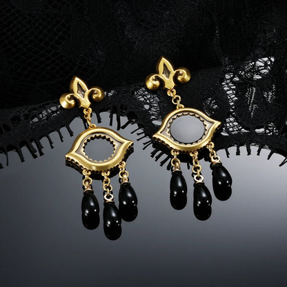 Gold-tone Votive Mirror Earrings displayed as a pair against black lace on a dark reflective surface.