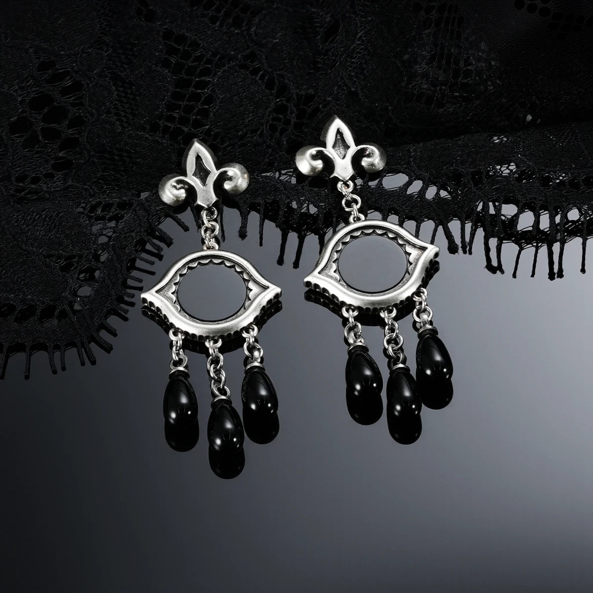 Antiqued silver-tone Votive Mirror Earrings displayed as a pair against black lace on a dark reflective surface.