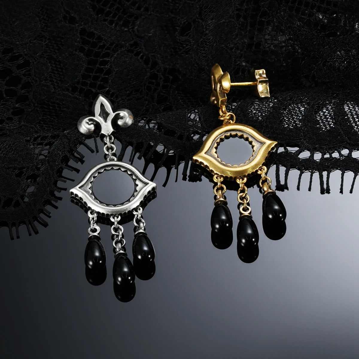 Antiqued silver- and gold-tone Votive Mirror Earrings displayed together against black lace on a dark reflective surface.
