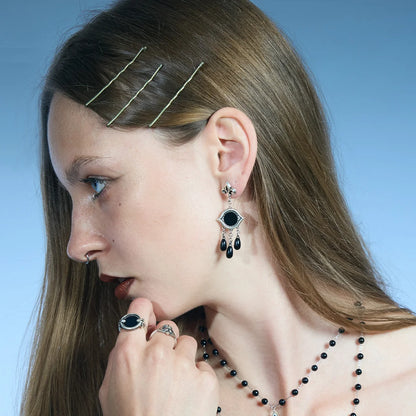 Antiqued silver-tone Votive Mirror Earrings worn in a downward-looking portrait, highlighting the layered black drop accents.