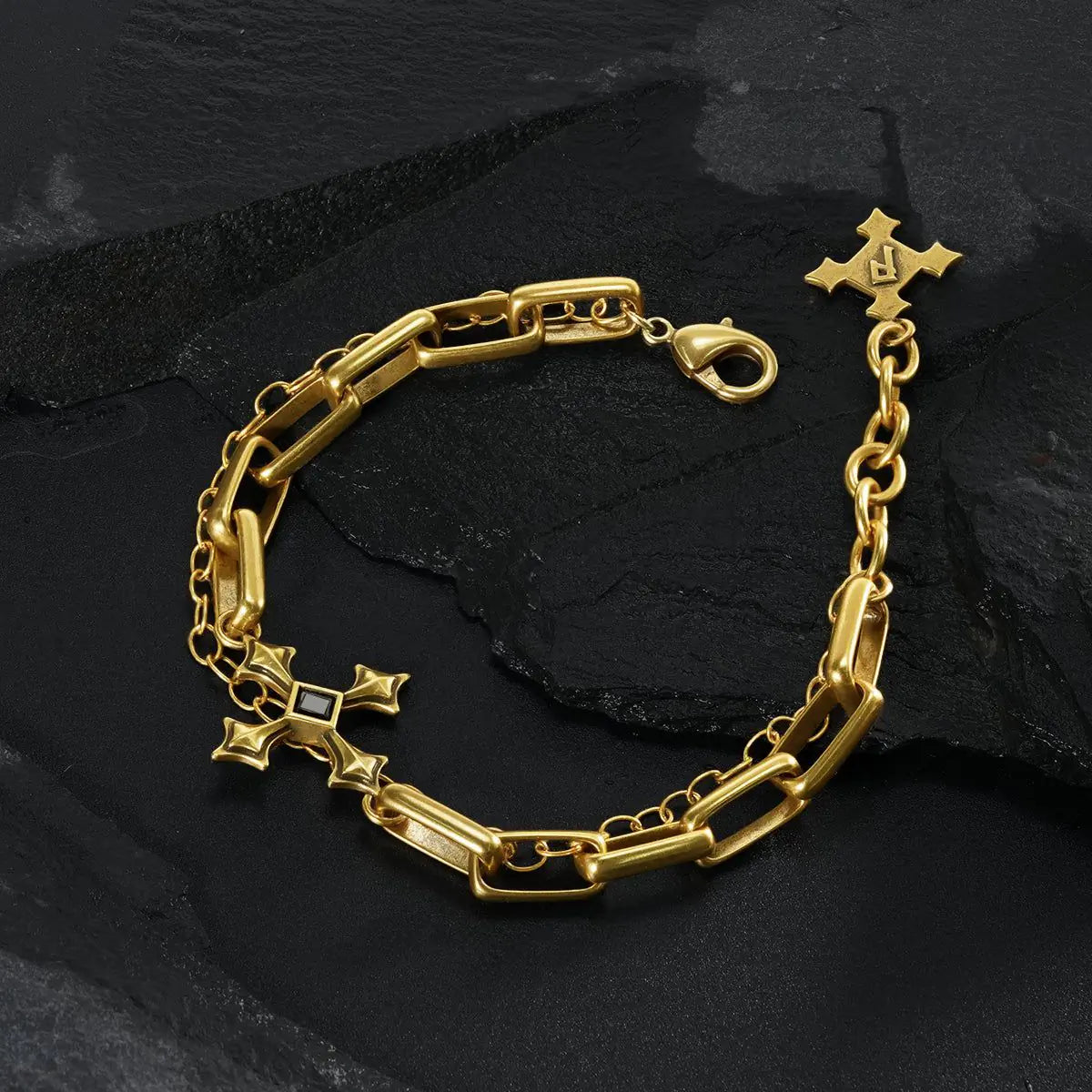 Gold Vowbound Chain Bracelet arranged in a full loop on black textured fabric.