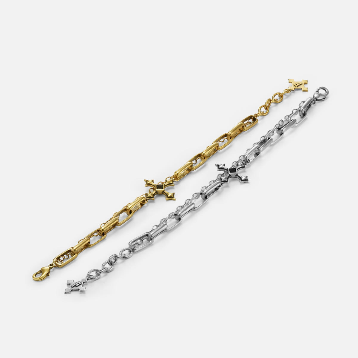 Silver and gold Vowbound Chain Bracelets extended side by side on white, highlighting the chain and cross details.