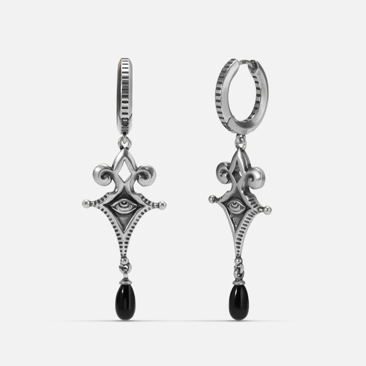 Antiqued silver-tone Watcher’s Tear Earrings shown from front and side views with engraved eye motifs and suspended black teardrop accents.