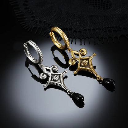 Antiqued silver- and gold-tone Watcher’s Tear Earrings displayed together against black lace on a dark reflective surface.