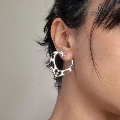 Model wearing silver Wild Heart Earrings with thorned heart hoop design and gothic jewelry styling