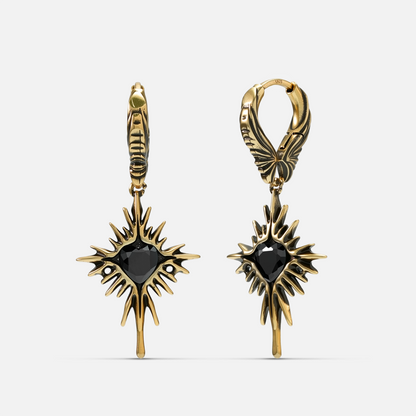 Pair of gold-tone Winged Heartburst hoop earrings shown from front and side with black heart centers