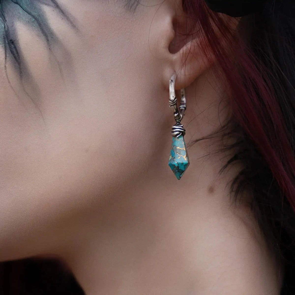 Wrapped Relic Earrings in 925 sterling silver, worn in a close ear view with dark red hair, showing the turquoise relic drop 