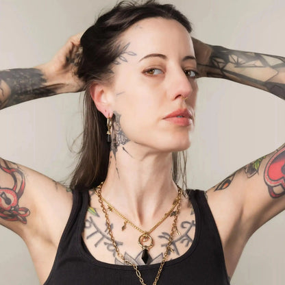Model wearing gold Wrapped Relic Earrings with obsidian stone drops and witchwood inspired styling