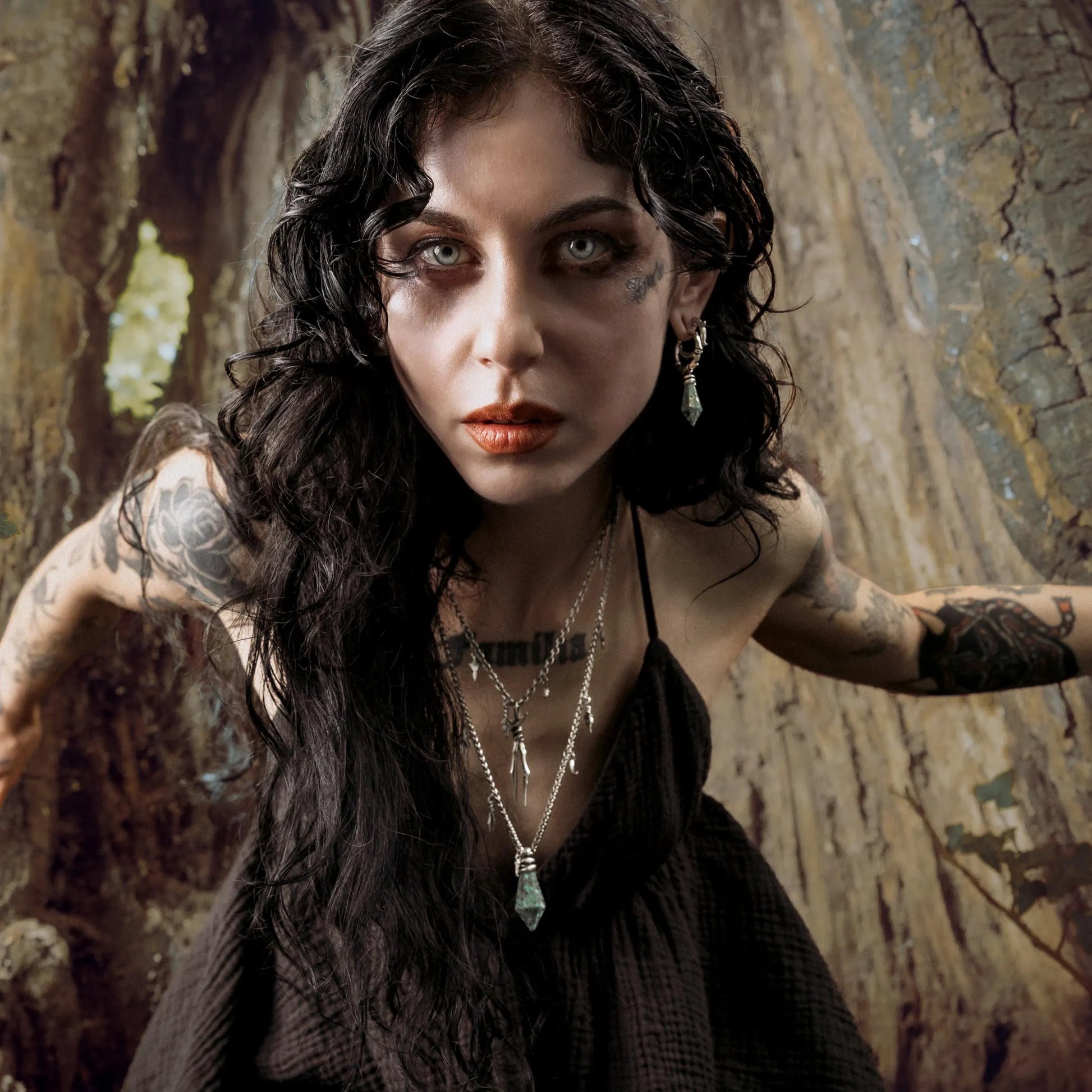 Model wearing Wrapped Relic Necklace in forest setting with dark woodland jewelry styling