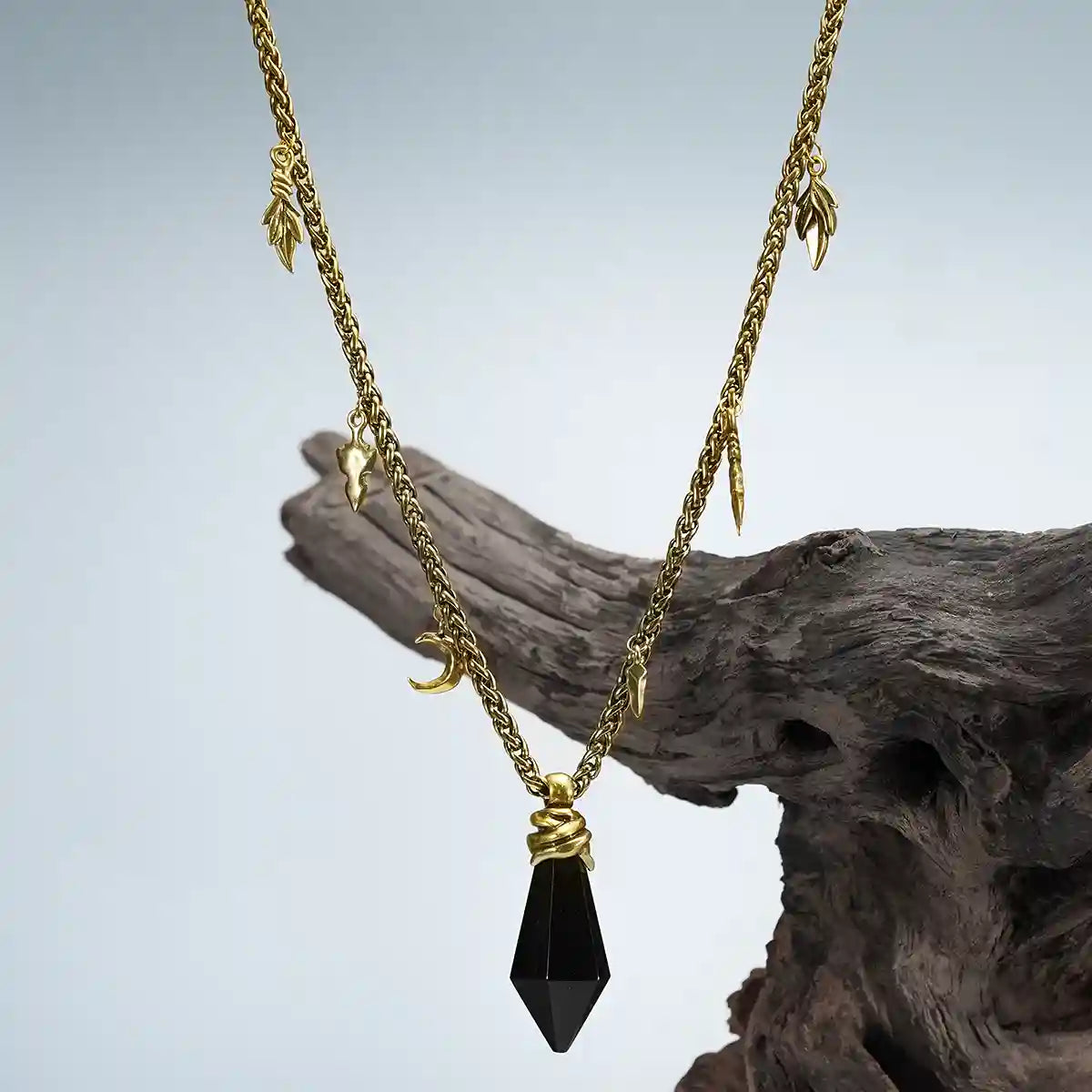 Gold Wrapped Relic Necklace with black obsidian pendant displayed on weathered wood