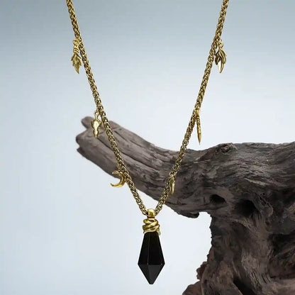 Gold Wrapped Relic Necklace with black obsidian pendant displayed on weathered wood