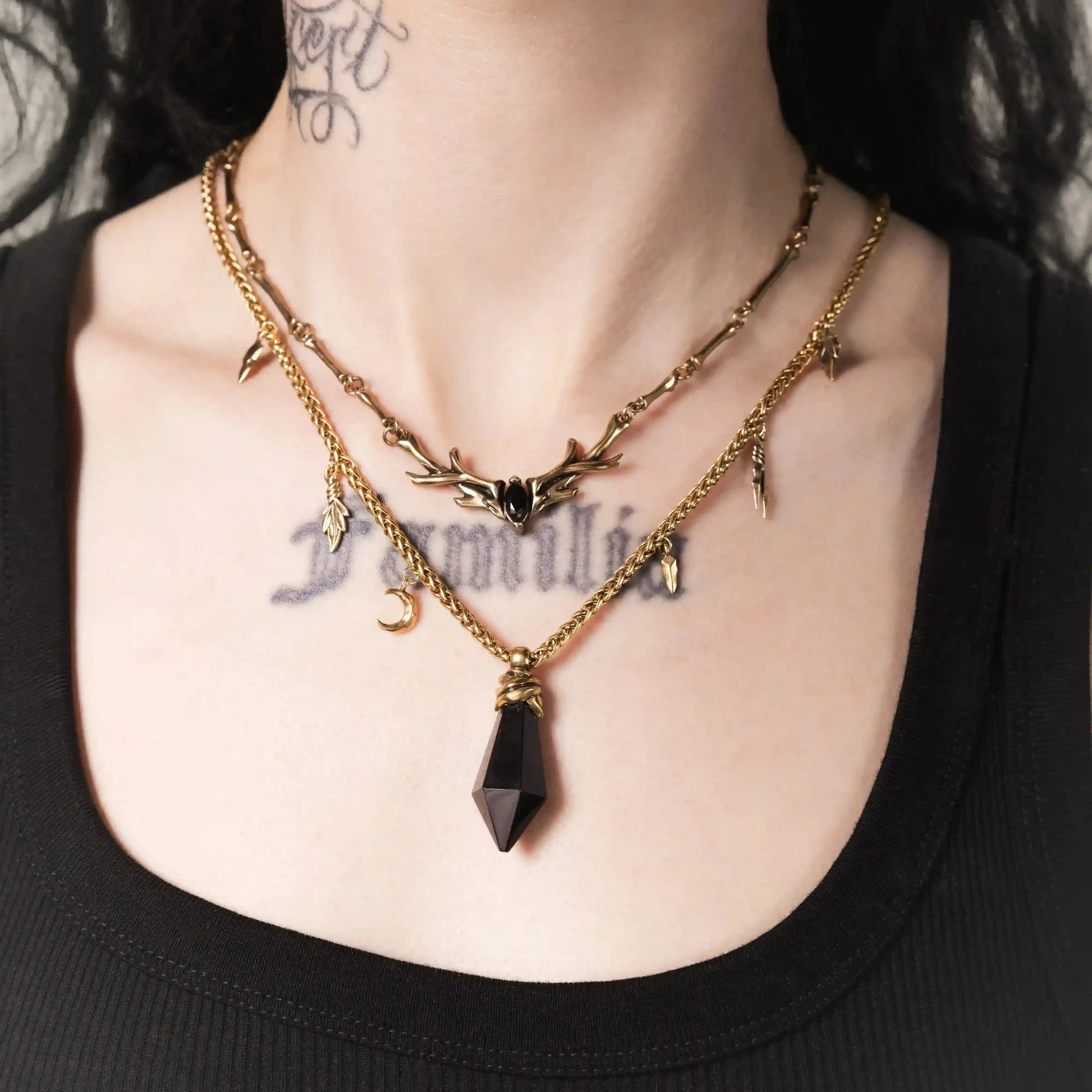 Model wearing the gold Wrapped Relic Necklace with black obsidian pendant and charm chain