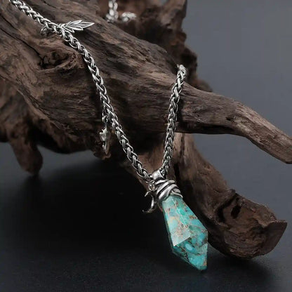 Silver Wrapped Relic Necklace with turquoise stone pendant displayed on weathered wood