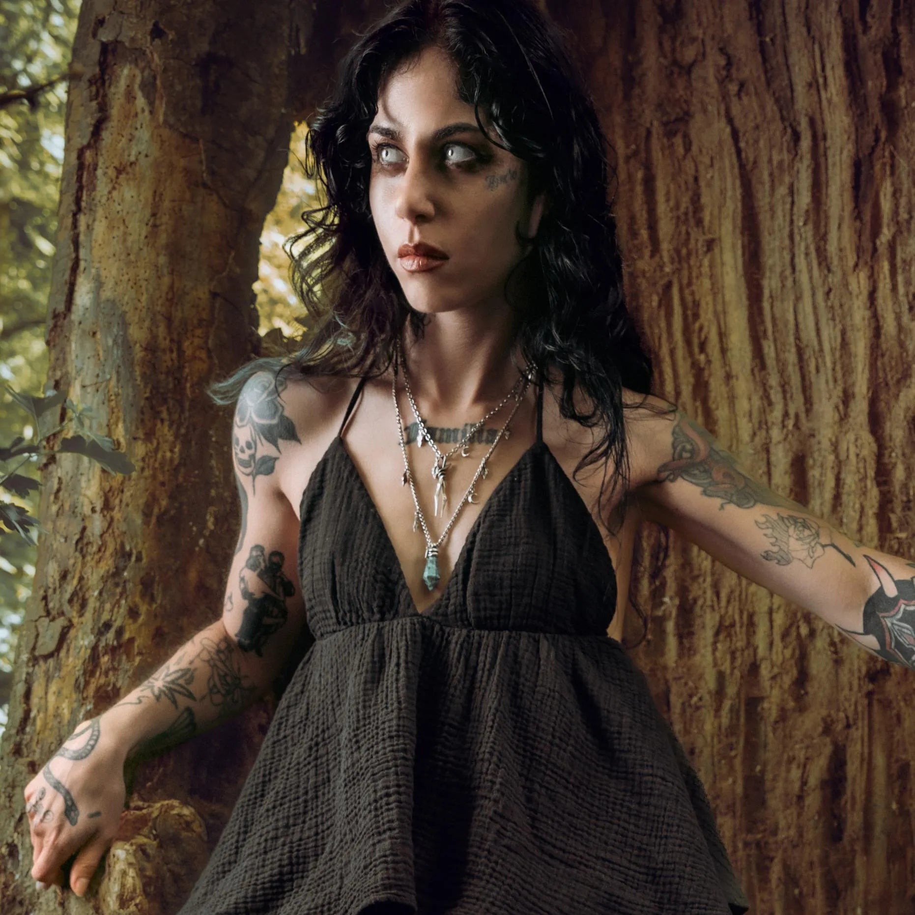 Model wearing Wrapped Relic Necklace beside an ancient tree with dark relic inspired styling